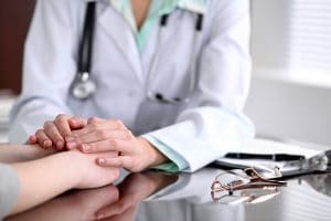 doctor holding hand of patient